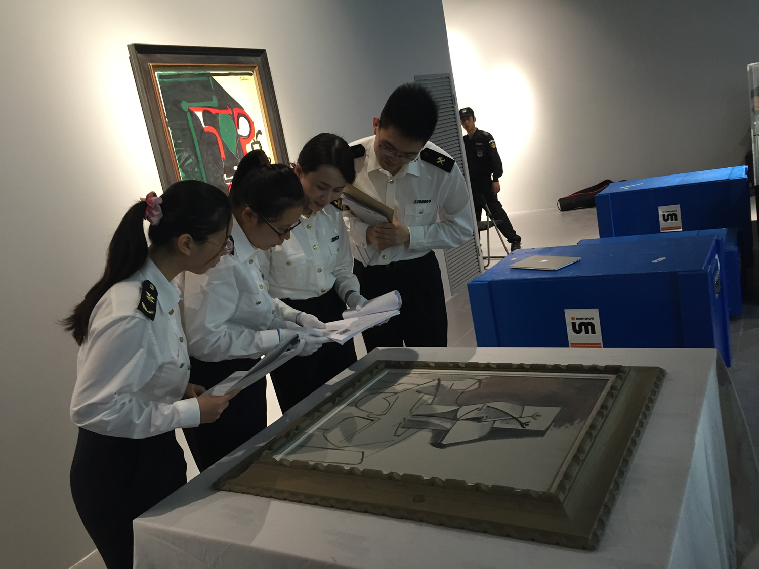 Inspection of framed works in a gallery